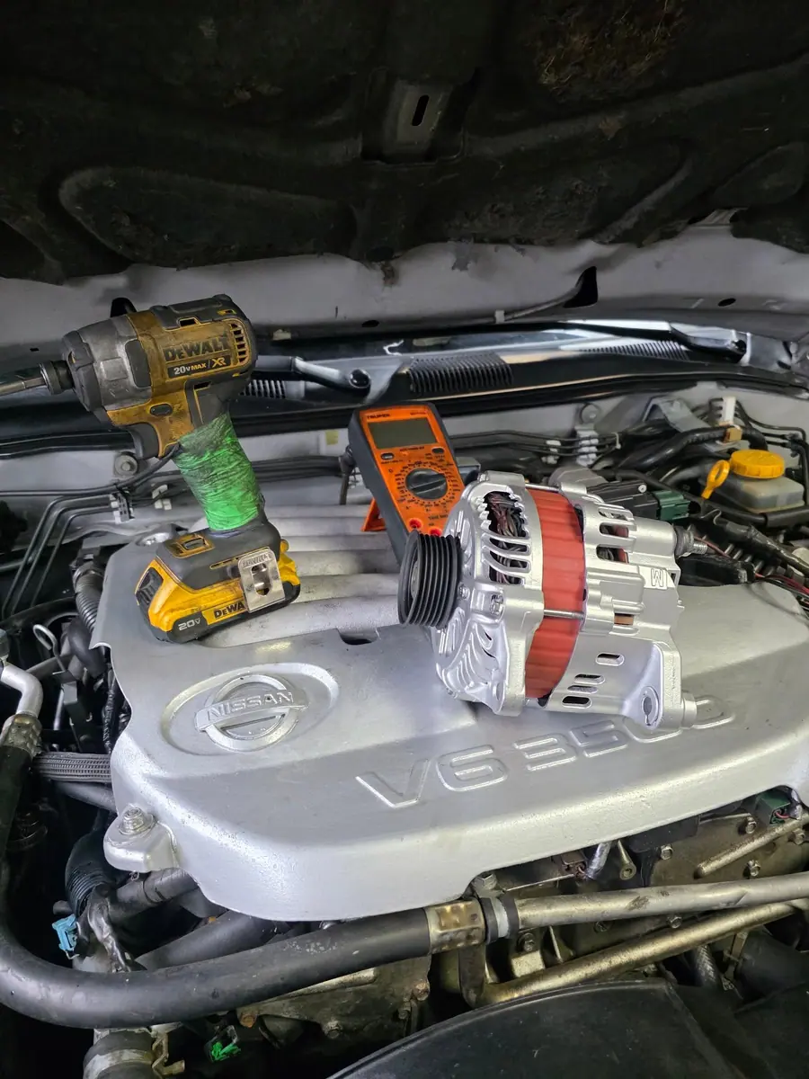 Alternador y herramientas sobre el motor de un pickup